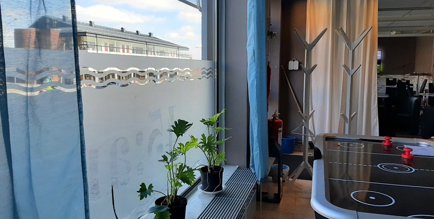 Bilden är tagen inifrån 45:ans lokaler och bilden är tagen på fönstret där det 45:an (fast bakvänt). I fönstret står några blommor.